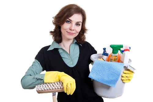 Carpet cleaner working carefully in a furnished room during service